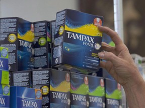 In this June 22, 2016 file photo, a woman restocks tampons at Compton's Market, in Sacramento, Calif. A Halifax university has become the first in the province to offer its students free menstrual products, part of a national movement that has been gaining steam among student leaders.