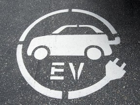 An electric vehicle charging sign is pictured in Squamish, B.C., Tuesday, June, 1, 2016. Cost and supply are the main challenges keeping Canadians from buying more electric vehicles, a survey of car sales reps suggests.