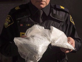 An OPP officer displays bags containing fentanyl as Ontario Provincial Police host a news conference in Vaughan, Ont., on February 23, 2017. Canada's police chiefs are urging Ottawa to beef up its fight against the opioid scourge by closely vetting people who import pill presses. In a resolution passed at their annual conference in Halifax, the Canadian Association of Chiefs of Police says federal changes last year that made it illegal to import unregistered pill presses did not go far enough. The chiefs say illicit use of such presses has helped increase the supply of street drugs containing synthetic opioids such as fentanyl, contributing to a crisis of overdose deaths.