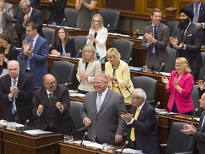 Ontario Premier Doug Ford is applauded by his PC Party members during Question Period at the Ontario Legislature in Toronto on July 30, 2018.