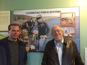 Alex Storm, right, poses with his son Jason Storm in front of a display about him and his treasure hunting days in this undated handout photo. A famous treasure hunter and historian of Cape Breton island, remembered as a restless adventurer and superb storyteller, has died. Alex Storm made headlines in 1965 when he and a small crew of divers discovered the French treasure ship Le Chameau off Cape Breton that had been lost for more than two centuries.