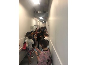 A crowd of people take shelter in a staff corridor following reports of gun shots at Yorkdale Shopping Centre in Toronto on Thursday, Aug. 30, 2018. A shooting at a major Toronto mall on Thursday afternoon sent shoppers running for cover as police searched for multiple suspects. No one was injured in the gunfire that police said took place on the east side of the Yorkdale Shopping Centre just before 3 p.m.