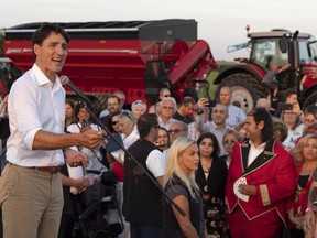 Prime Minister Justin Trudeau addresses local Liberals and Liberal MPs from the South Shore of Montreal for a summer corn roast in Sabrevois, Que., on Thursday, August 16, 2018. The Prime Minister's Office is refusing to say precisely when â€" or even if â€" Justin Trudeau knew he was dealing with an alt-right activist when he denounced her questions about the cost of "illegal immigrants" in Quebec as intolerant and racist.