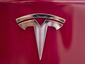 A Tesla emblem is seen on the back end of a Model S in the Tesla showroom in Santa Monica, Calif., on Wednesday, Aug. 8, 2018. An Ontario court has ruled in favour of the Canadian arm of Tesla Inc. it its petition that it had been treated unfairly in the provincial government's cancellation of an electric vehicle rebate program. Ontario Superior Court judge Frederick L. Myers said the decision to exclude Tesla from a grace period for the program's wind-down was arbitrary and had singled out Tesla for harm.