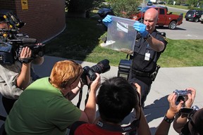 Bylaw officer Todd Kabeya holds a dead rat found in the Auburn bay area of Calgary, Alberta, on August 17, 2012. A search was made of the area but there were no other rats found.