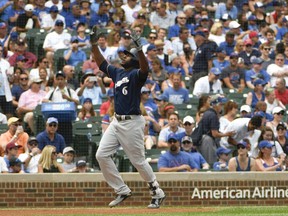 Milwaukee Brewers' Lorenzo Cain gestures as he's about to cross home plate after hitting a home run against the Chicago Cubs during the first inning of a baseball game,Tuesday, Aug. 14, 2018, in Chicago.