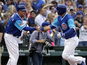 Chicago Cubs' David Bote, right, celebrates with third base coach Brian Butterfield as he rounds the bases after hitting a winning solo home run during the 10th inning of a baseball game against the Cincinnati Reds, Friday, Aug. 24, 2018, in Chicago.