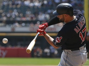 Cleveland Indians' Yonder Alonso hits an RBI single against the Chicago White Sox during the first inning of a baseball game Sunday, Aug. 12, 2018, in Chicago.