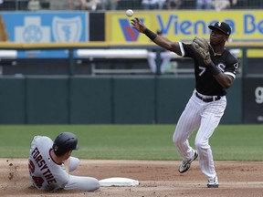 Chicago White Sox shortstop Tim Anderson, right, throws to first after forcing out Minnesota Twins' Logan Forsythe at second during the first inning of a baseball game Wednesday, Aug. 22, 2018, in Chicago. Minnesota Twins' Eddie Rosario was safe at first.