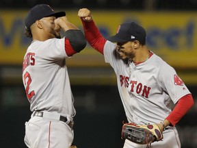 Boston Red Sox's Mookie Betts, right, and Xander Bogaerts celebrate the team's 9-4 win over the Chicago White Sox in a baseball game Thursday, Aug. 30, 2018, in Chicago.