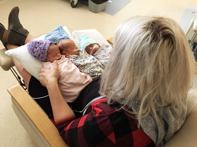 Danielle Johnston holds her newborn triplets Karlee, Liam and Jack. The Saskatchewan mother had to perform CPR on one of the triplets while she was still in labour.