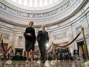 Senate Majority Leader Mitch McConnell of Ky., center, accompanied by an aide, walks through the Rotunda before the casket of Sen. John McCain, R-Ariz., lies in state at the U.S. Capitol, Friday, Aug. 31, 2018, in Washington.