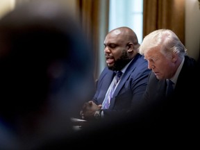 President Donald Trump, right, bows his head as Relentless Church Pastor John Gray, left, says a prayer during a meeting with inner city pastors in the Cabinet Room of the White House in Washington, Wednesday, Aug. 1, 2018.