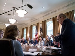 White House chief economic adviser Larry Kudlow, right, accompanied by Secretary of Veterans Affairs Robert Wilkie, left, and CIA Director Gina Haspel, second from left, gives a report on the economy during a cabinet meeting with President Donald Trump, background at left, in the Cabinet Room of the White House, Thursday, Aug. 16, 2018, in Washington.