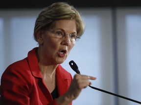 Sen. Elizabeth Warren, D-Mass., gestures while speaking at the National Press Club in Washington, Tuesday, Aug. 21, 2018. Warren wants a lifetime ban on members of Congress from getting hired as lobbyists after they leave public office. She also wants to prohibit lawmakers from owning or trading individual stocks while in office.