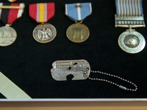 A dog tag from Master Sgt. Charles Hobert McDaniel, who died in the Korean War in 1950 and was among recently repatriated remains from North Korea, is displayed with his service medals during a ceremony by military officials, Wednesday, Aug. 8, 2018, in Arlington, Va.