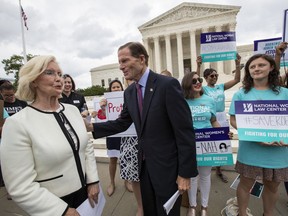 Lilly Ledbetter, an activist for workplace equality, left, is joined by Sen. Richard Blumenthal, D-Conn., a member of the Senate Judiciary Committee, as they address demonstrators opposed to President Donald Trump's Supreme Court nominee, Judge Brett Kavanaugh, in front of the Supreme Court, in Washington, Wednesday, Aug. 22, 2018.