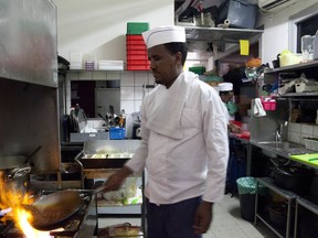 In this Wednesday, Aug. 8, 2018 photo, Eritrean migrant Russom Weldu Weldeslasie works at a restaurant in Tel Aviv, Israel. African migrants coming into Israel have been detained, threatened with deportation and faced hostility from lawmakers and residents. Now, they face another burden: a de facto 20 percent salary cut that has squeezed them financially and driven them further into poverty.