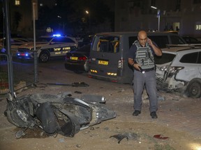 Israeli security stands at the site where a missile from Gaza Strip hit in the town of Sderot, Wednesday, Aug. 7, 2018. Sirens wailed in southern Israel warning of incoming projectiles from Gaza and Israeli media reported two people were lightly injured from shrapnel in the border town of Sderot.