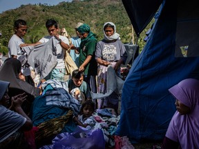 Villagers scramble for used clothing at temporary shelter in Pemenang on August 12, 2018 in Lombok Island, Indonesia. Over 300 people died after a 6.9-magnitude earthquake hit the Indonesian island, Lombok, on Sunday followed by a series of aftershocks which left at least 270,000 people displaced and around 8,400 tourists and resort workers evacuated from the Gili islands.