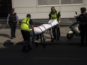 A body is taken on a stretcher by mortuary service members, outside a Police station following an attack in Cornella de Llobregat near Barcelona, Spain, Monday, August 20, 2018. Police in Barcelona say they have shot a man who attacked officers with a knife at a police station in the Spanish city, saying in a tweet Monday the attack occurred just before 6 a.m. in the Cornella district of the city.