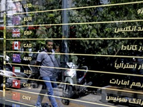 Various currencies are displayed without the going rate on a money exchange shop window in downtown Tehran, Iran, Tuesday, Aug. 7, 2018. Money exchange shops across Iran cautiously reopened on Tuesday after being shut for five months amid economic turmoil fanned by America's withdraw from the nuclear deal.