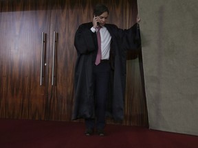 Luiz Fernando Pereira, defense lawyer for Brazil's Former President Luiz Inacio Lula da Silva, speaks on his cell phone during the trial against the candidacy of former president da Silva for the presidential elections, in Brasilia, Brazil, Friday, Aug. 31, 2018. Brazil's general elections will be held on October 7.