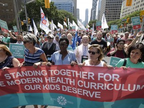 Ontario elementary teachers supporters make their way up University Ave in protest to the sex-ed rollback at Queen's Park in Toronto Tuesday August 14, 2018.