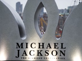 A fan of the former King of Pop Michael Jackson takes pictures whilst celebrating Jacksons Diamond Birthday Celebration with the installation of a giant 13 foot jewelled crown at London's iconic Southbank in London, Wednesday, Aug. 29, 2018.