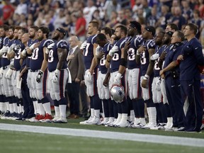 New England Patriots players stand for the national anthem before a preseason NFL football game against the Philadelphia Eagles, Thursday, Aug. 16, 2018, in Foxborough, Mass.