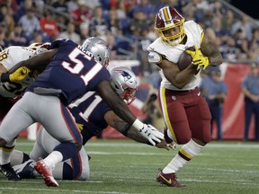 Washington Redskins running back Derrius Guice, right, evades New England Patriots linebacker Ja'Whaun Bentley (51) and defensive tackle Danny Shelton, center, during the first half of a preseason NFL football game, Thursday, Aug. 9, 2018, in Foxborough, Mass.