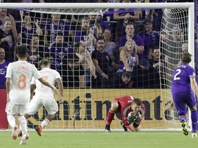 Orlando City goalkeeper Joseph Bendik, second from right, blocks a shot attempt by Atlanta United's Josef Martinez, second from left, during the first half of an MLS soccer match Friday, Aug. 24, 2018, in Orlando, Fla.