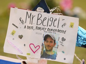 FILE - This Feb. 20, 2018, file photo shows a memorial for Geography teacher and cross-country coach, Scott Beigel at Pine Trails Park in Parkland, Fla. A street in New York's Long Island has been named for Beigel who helped shield students from the gunman in last winter's school shooting. The street where Beigel grew up in Dix Hills, N.Y., was dedicated "Scott J. Beigel Way" on Saturday Aug. 11.