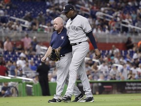 New York Yankees relief pitcher Aroldis Chapman, right, leaves the game with an injury during the twelfth inning of a baseball game against the Miami Marlins, Tuesday, Aug. 21, 2018, in Miami. The Yankees won 2-1 in twelve innings.