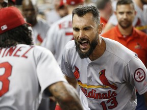 St. Louis Cardinals' Carlos Martinez, left, celebrates with Matt Carpenter (13), who hit a home run during the eighth inning of the team's baseball game against the Miami Marlins, Tuesday, Aug. 7, 2018, in Miami. Carpenter hit his 30th home run, a tiebreaking drive that lifted the Cardinals over the Marlins 3-2.