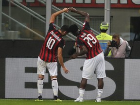 AC Milan's Franck Kessie, right, celebrates with teammate Hakan Calhanoglu after scoring his side's opening goal during the Serie A soccer match between AC Milan and Roma at the Milan San Siro Stadium, Italy, Friday, Aug. 31, 2018.