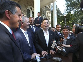 FILE - In this Sept. 4, 2014, file photo, Nevada Gov. Brian Sandoval, from left, executive director of the Governor's office of economic development Steve Hill and Telsa Motors CEO Elon Musk answer questions following a news conference at the Capitol in Carson City, Nev.  Tesla added more than 800 employees and $459 million in capital investment at the giant factory in Nevada that manufactures batteries for its electric cars during the fourth quarter of last year. The latest tax incentive audit from the Nevada Governor's Office of Economic Development shows private spending surged past the benchmark needed to ensure Tesla's state tax breaks, the Reno Gazette-Journal reported Tuesday, Aug. 21, 2018.