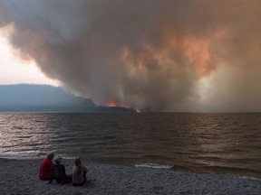 In this Sunday, Aug. 12, 2018, the Howe Ridge Fire burns at Glacier National Park, Mont. At least nine homes and cabins in a historic district of Glacier National Park have been destroyed in a wildfire that raged through the Montana park's busiest area and prompted the hasty evacuation of hundreds of visitors. Park officials said Tuesday, Aug. 14, 2018, that the lost buildings include the so-called Big House at Kelly's Camp, a resort developed early last century serving auto travelers along Glacier's famous Going-to-the-Sun Road.