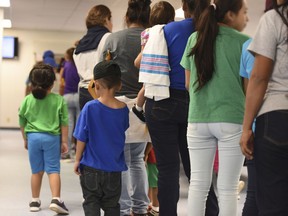 FILE - In this Aug. 9, 2018, file photo, provided by U.S. Immigration and Customs Enforcement, mothers and their children stand in line at South Texas Family Residential Center in Dilley, Texas. A complaint expected to be filed Thursday, Aug. 23 with the Department of Homeland Security alleges that immigration authorities coerced dozens of parents separated from their children at the border to sign documents they didn't understand. In some of those cases, parents gave away rights to be reunited with their kids. The complaint will be filed by the American Immigration Lawyers Association and the American Immigration Council.