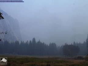 In this Wednesday, Aug. 1, 2018 image from a Yosemite Conservancy webcam, smoke from wildfires obscures the Ahwahnee Meadow at Yosemite National Park, Calif. Yosemite National Park could reopen its scenic valley and other areas Monday, Aug. 6, 2018, if conditions improve after a 12-day closure due to nearby wildfires. The park's iconic cliffs have been shrouded in so much smoke that the air quality in Yosemite is currently worse than Beijing. (Webcam by Yosemite Conservancy via AP)