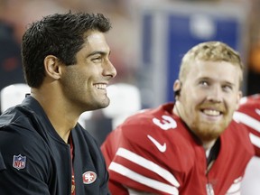 San Francisco 49ers quarterback Jimmy Garoppolo, left, smiles on the sideline next to quarterback C.J. Beathard (3) during the first half of an NFL preseason football game against the Los Angeles Chargers in Santa Clara, Calif., Thursday, Aug. 30, 2018.