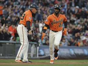 San Francisco Giants' Andrew McCutchen circles the bases and heads for home plate after hitting a home run off Pittsburgh Pirates starting pitcher Clay Holmes in the first inning of a baseball game Friday, Aug. 10, 2018, in San Francisco. At left is Giants third base coach Ron Lotus.