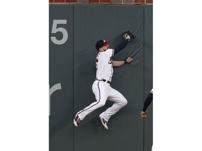 Atlanta Braves center fielder Ender Inciarte crashes into the wall as he makes a catch to retire Pittsburgh Pirates' David Freese during the first inning of a baseball game Friday, Aug. 31, 2018, in Atlanta.