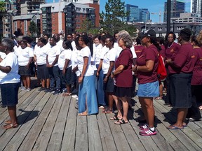Karen Burke (left), director of Toronto Mass Choir, and singers from the Nova Scotia Mass Choir and the Toronto Mass Choir, are shown in Halifax, Saturday, Aug.4, 2018 Two award-winning Canadian gospel choirs wowed unsuspecting pedestrians on a busy waterfront Saturday morning with an impromptu performance.