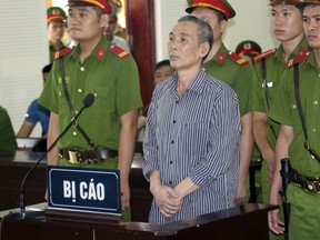 Activist Le Dinh Luong, center, stands trial in central province of Nghe An, Vietnam, Thursday, Aug. 16, 2018. Luong was sentenced to 20 years in prison after the court found him guilty of attempting to overthrow the government at the one-day trial. It was one of the toughest sentences in years for national security crimes. International human rights groups have called for his release.
