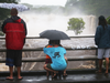 People gather on a bridge to watch the Wailuku River flood waters on the Big Island on Aug. 23, 2018 in Hilo, Hawaii.