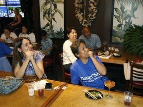 Guests at Hawaii Lt. Gov. Doug Chin's campaign party react to election results, Saturday, Aug. 11, 2018, in Honolulu.