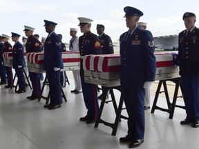Military members stand at attention after placing transfer cases in a hanger at a ceremony marking the arrival of the remains believed to be of American service members who fell in the Korean War at Joint Base Pearl Harbor-Hickam in Hawaii, Wednesday, Aug. 1, 2018. North Korea handed over the remains last week.