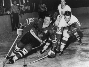 In this Feb. 24, 1965 file photo, Chicago Blackhawks forward Stan Mikita (left) pulls away from Detroit Red Wings forward Ted Lindsay.