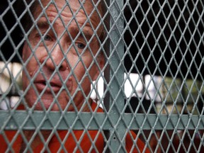 Australian filmmaker James Ricketson sits in a prison truck upon his arrival at Phnom Penh Municipal Court in Phnom Penh, Cambodia, Thursday, Aug. 16, 2018. Ricketson has gone on trial in Cambodia on charges of endangering national security after being arrested last year for flying a drone to capture images of an opposition political rally.